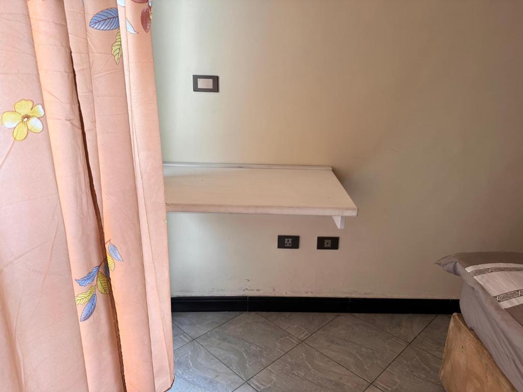 a small room with a bed with pink curtains at Condo near to the airport, beside Shola supermarket and close to Megenagna square in Addis Ababa