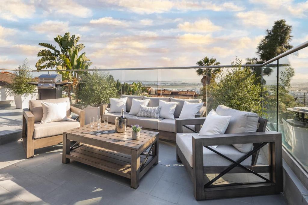 eine Terrasse mit Sofas und einem Tisch auf dem Balkon in der Unterkunft 3 Bedroom with Ocean View Jacuzzi and Parking in San Diego