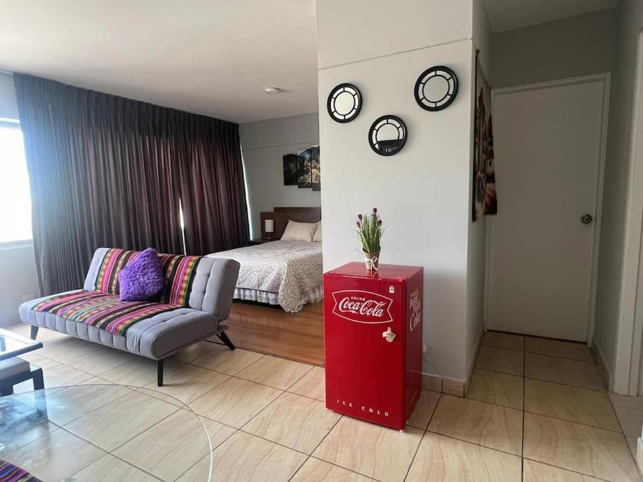 a living room with a cocacola refrigerator and a couch at Studio Apartment in Miraflores in Lima