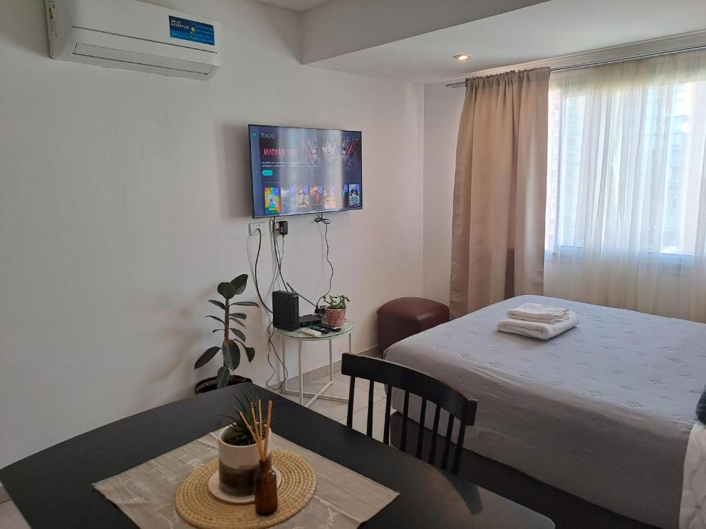 een kamer met een bed, een tafel en een televisie bij Cómodo monoambiente en Salta 246 in Neuquén