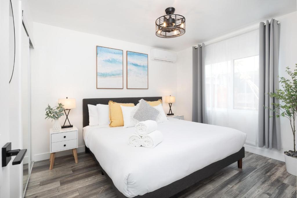 a bedroom with a large white bed and a window at 3 Bed House with Fire Pit Table and BBQ - Downtown in San Diego