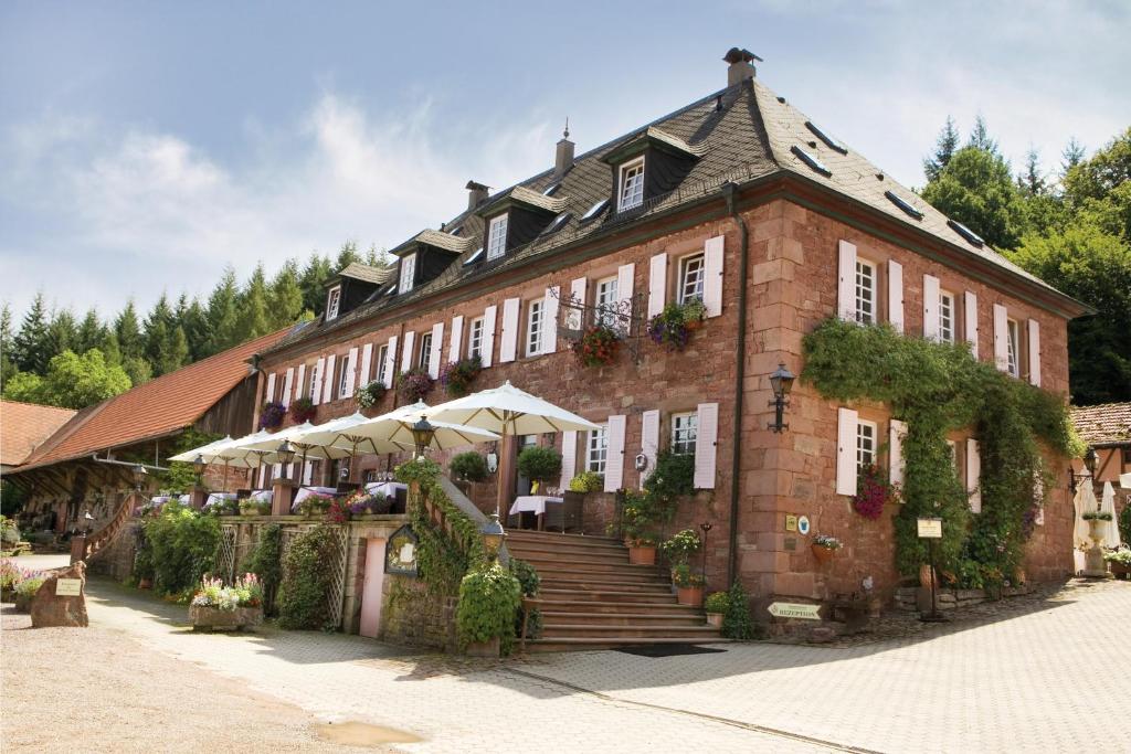 um grande edifício de tijolos com escadas e plantas em Landhotel der Schafhof Amorbach em Amorbach