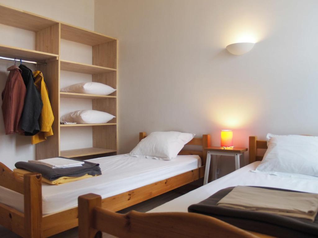 a bedroom with two beds and a closet with a suitcase at Gîte Les Pingouins de l'Aber in Brélès