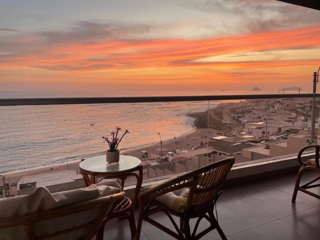 a balcony with a table and chairs and a view of the ocean at Apartamento Playa Señoritas in Punta Hermosa