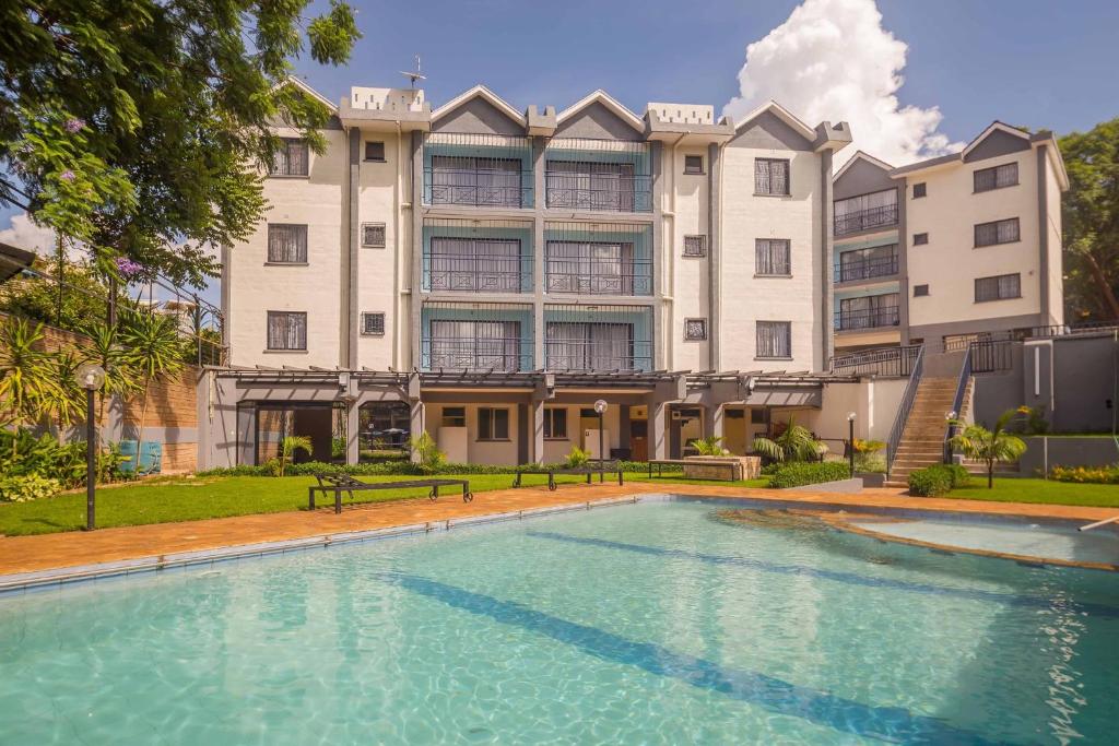 ein großes Gebäude mit einem Pool davor in der Unterkunft Sports Road Apartments by Dunhill Serviced Apartments in Nairobi
