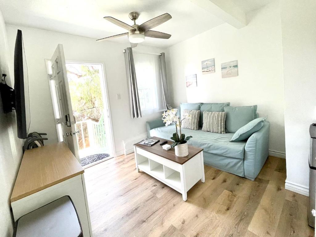 ein Wohnzimmer mit einem blauen Sofa und einem Tisch in der Unterkunft Hidden Gem with Hot Tub and Parking - 4 Guests in San Diego
