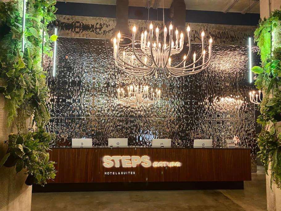 un lustre suspendu à un mur dans une pièce dans l'établissement Steps Batumi - One Bedroom corner unit ocean view, à Batoumi