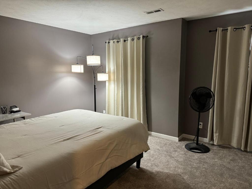a bedroom with a bed and a floor fan at Condo Townhome - Cleveland Lake Area 