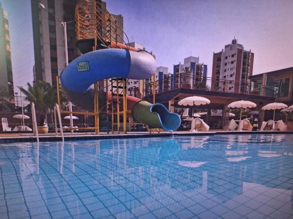 a swimming pool with a water slide in a city at Apartamento Millenium Thermas Residence 103 - B in Caldas Novas