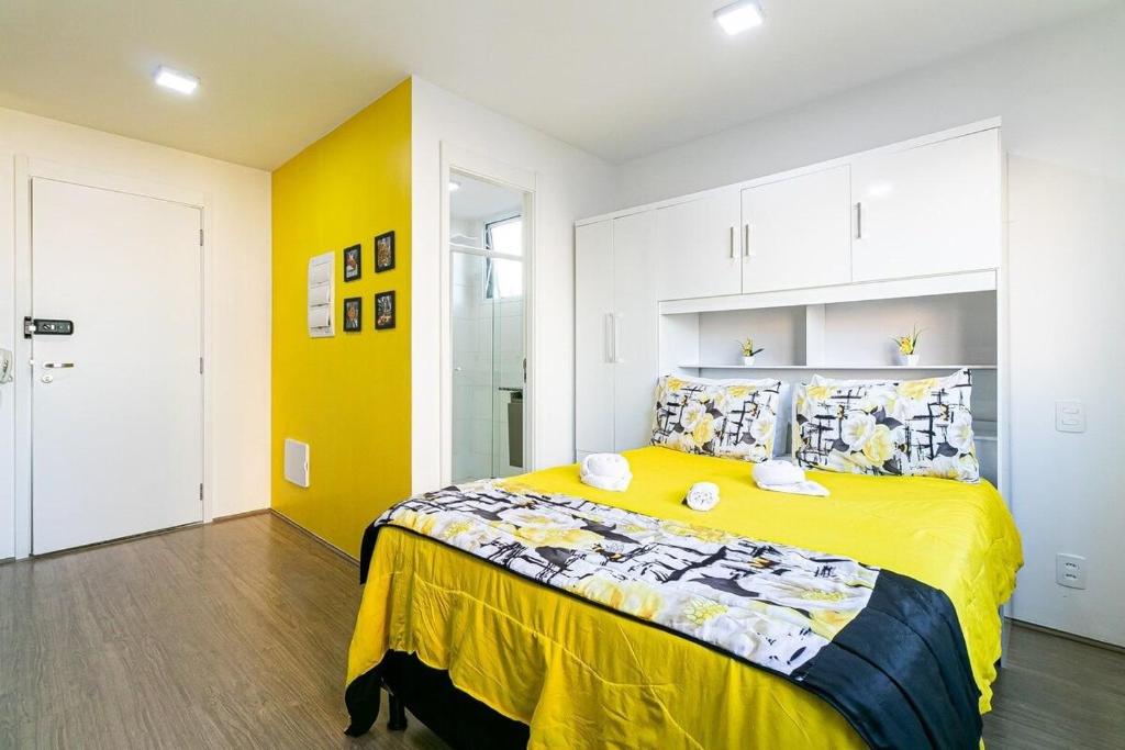 1 dormitorio con 1 cama amarilla en una habitación en Tranquilo Studio no Brás com Piscina/Metrô Brás, en São Paulo