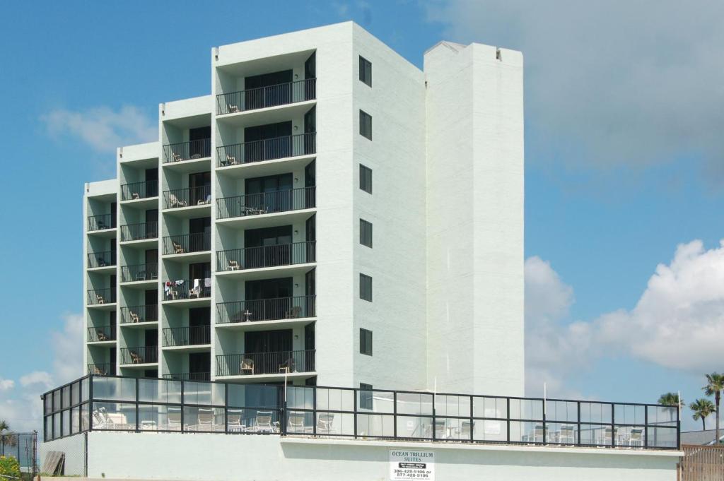 a white building with balconies on the side of it at Ocean Trillium Suites in New Smyrna Beach