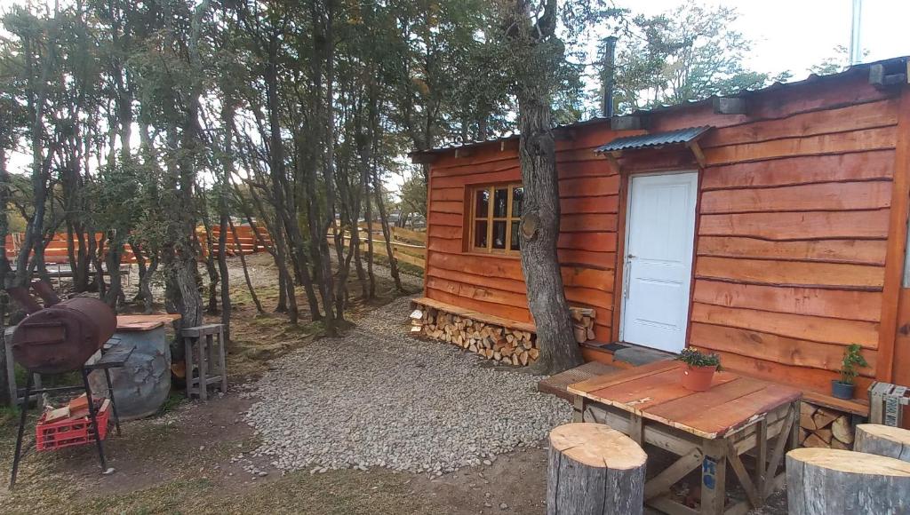 a log cabin with a table and a door at alojamientos CM in Tolhuin