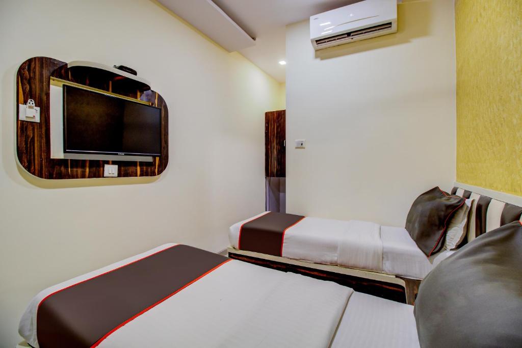 a small room with a bed and a tv at Golden Tulipz Boutique in Mumbai