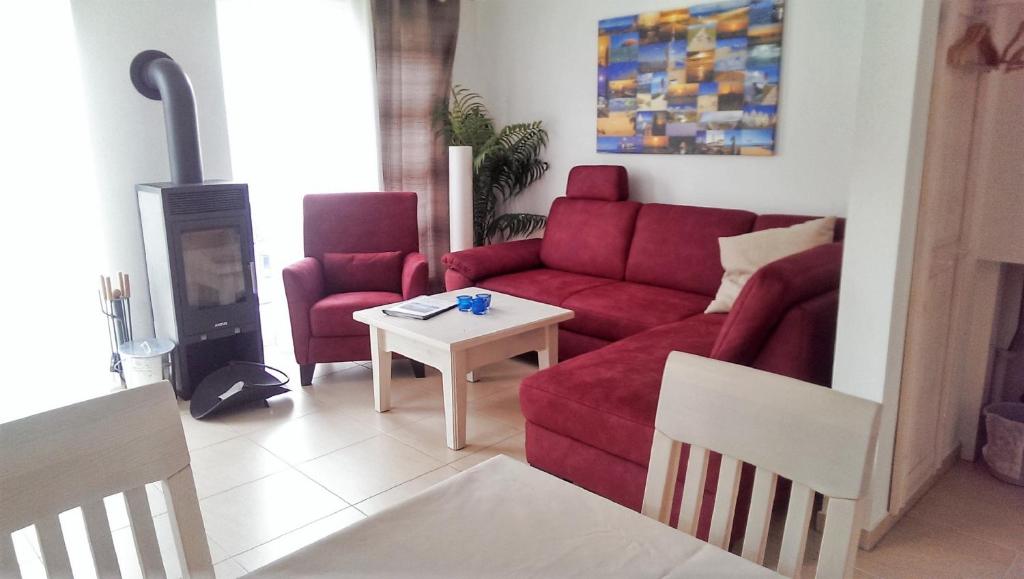 uma sala de estar com um sofá vermelho e uma mesa em Haus Annette em Glowe