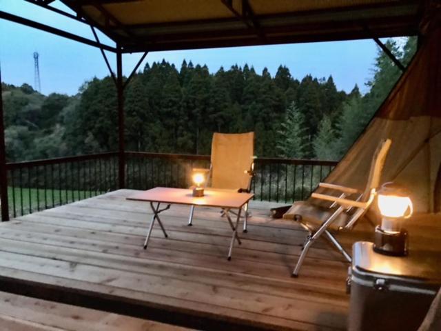 a deck with a tent and a chair and candles at ビラ里山双林 in Inashiki