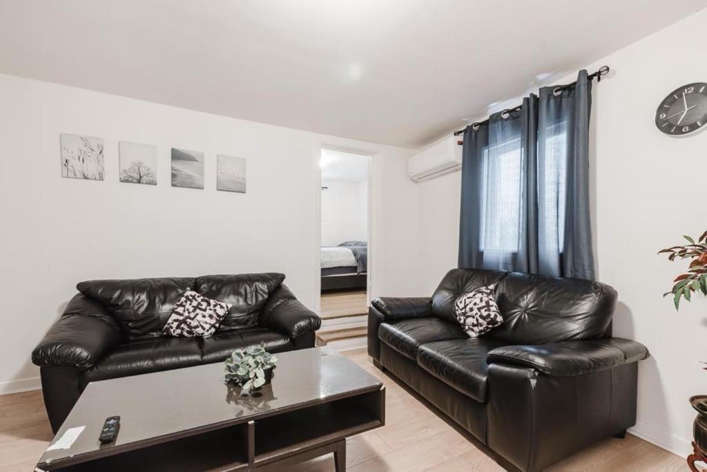 - un salon avec deux canapés en cuir et une table dans l'établissement 2 bedroom apartment in Lasalle - 72A, à Montréal