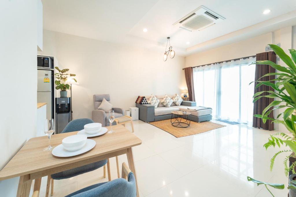 - un salon avec une table et un canapé dans l'établissement Baan Promphan Premium, à Phuket