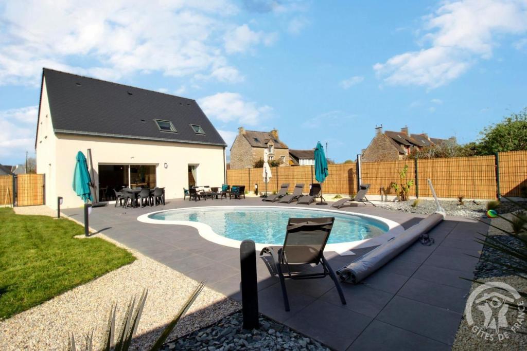 a backyard with a swimming pool and a house at La villa detente in Saint-Cast-le-Guildo