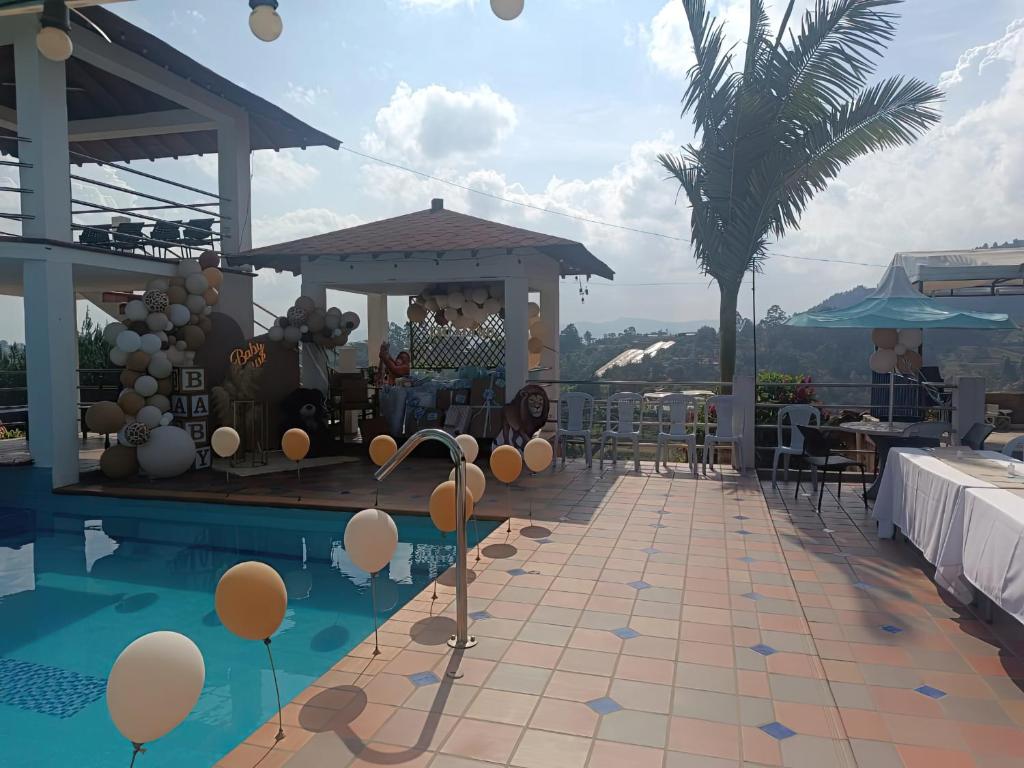 a swimming pool with balloons and a gazebo on a house at Finca con Piscina Privada/Jacuzzi/Asador in San Vicente
