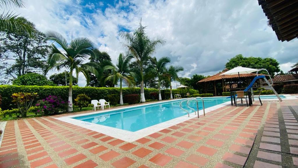 una piscina con un tobogán junto a un complejo en FINCA HOTEL JARDIN CAFETERO DEL QUINDIO, en Quimbaya