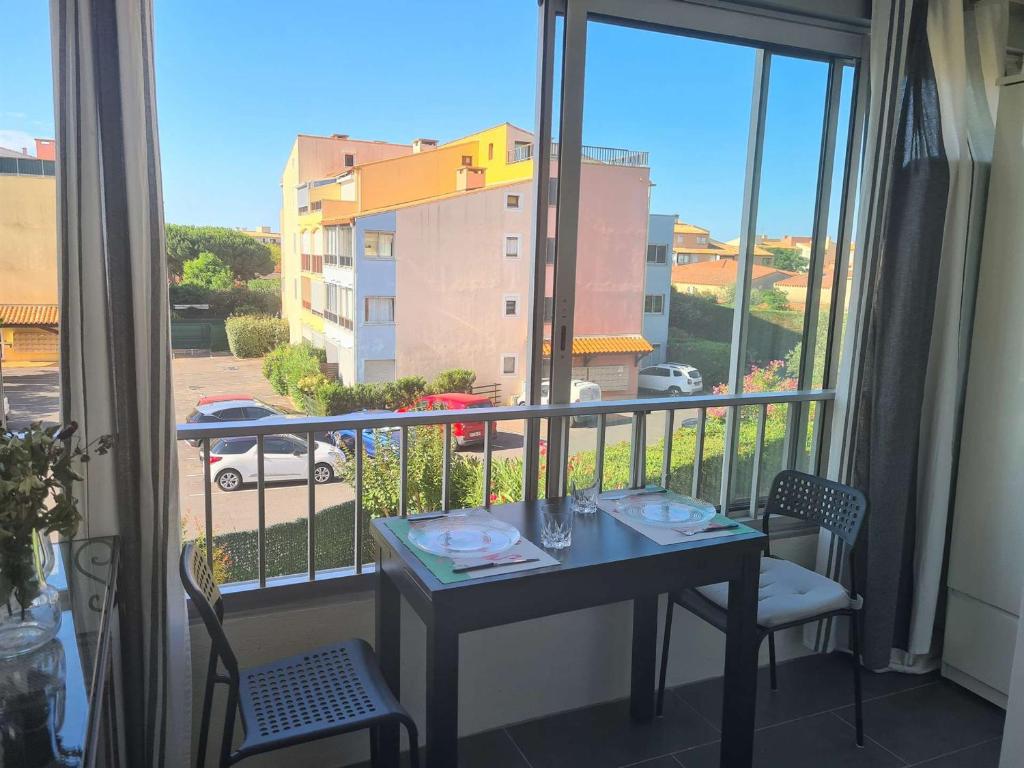 - une table sur un balcon avec vue sur un bâtiment dans l'établissement Appartement T2 avec Loggia à 500m du Port et Proche Plage - Cap d'Agde - FR-1-249-405, au Cap d'Agde