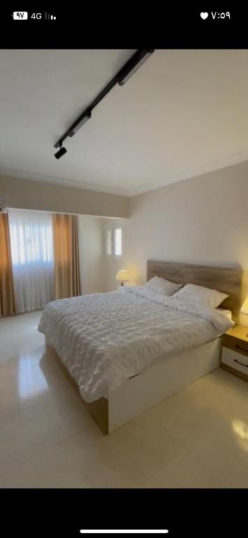 a bedroom with a large white bed in a room at شقه فندقيه تشاهد النيل in Cairo