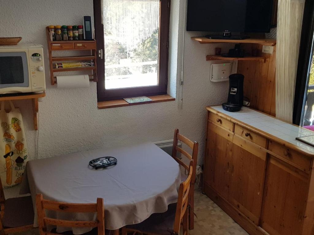 une petite cuisine avec une table et un four micro-ondes dans l'établissement Appartement Châtel, 2 pièces, 4 personnes - FR-1-676-187, à Châtel