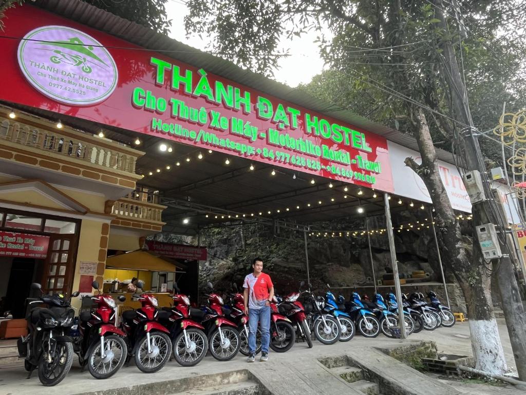 Ein Mann steht vor einer Reihe von Motorrädern in der Unterkunft Thành Đạt Hostel ( Hostel and Motobike Rental ) in Bản Tùy