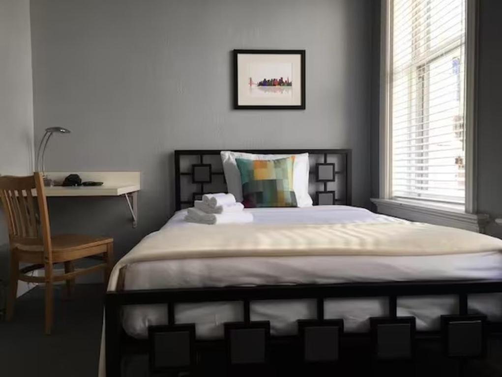 um quarto com uma cama com uma cadeira e uma secretária em The Urban em São Francisco