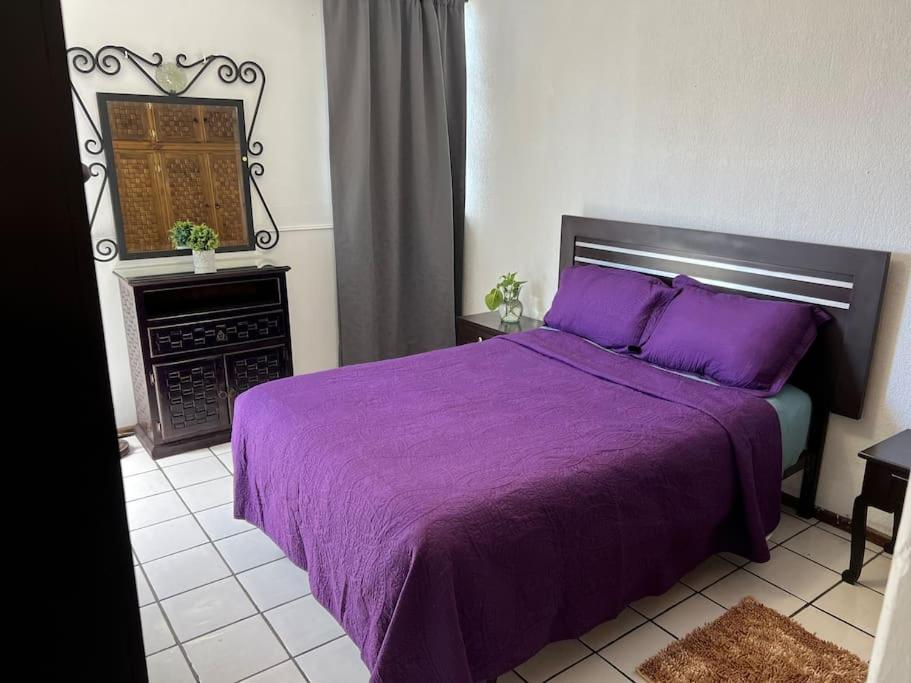 - une chambre avec un lit violet et une cheminée dans l'établissement Caza en zona residencial, à Uruapan del Progreso
