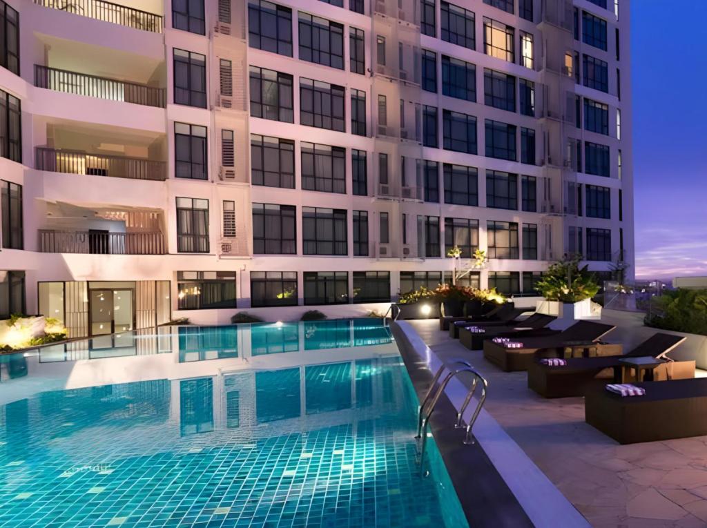 a swimming pool in front of a building at night at Citadines Uplands Kuching in Kuching