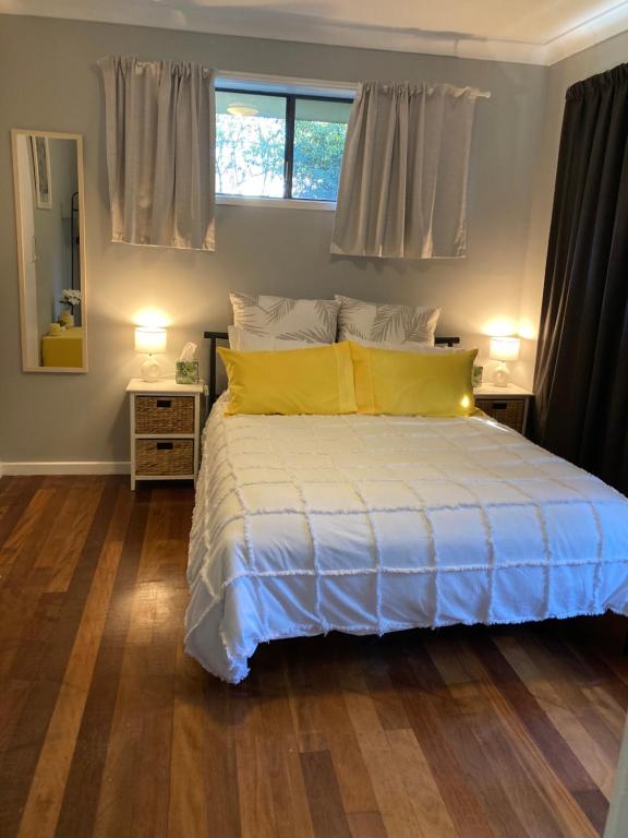 Armidale的住宿－Lennox House，一间卧室配有一张带黄色枕头的床和一扇窗户