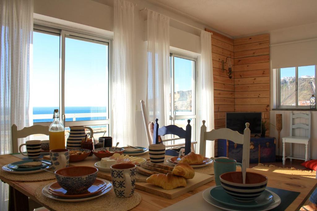 una mesa con comida en ella en una habitación con ventanas en Casa Azul, en Nazaré