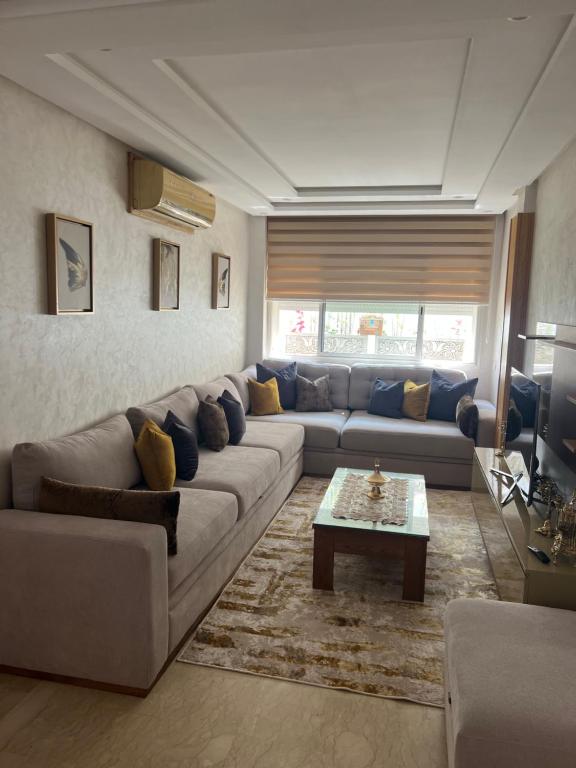un soggiorno con divano e tavolino da caffè di Appartement bien meublé a Skhirat