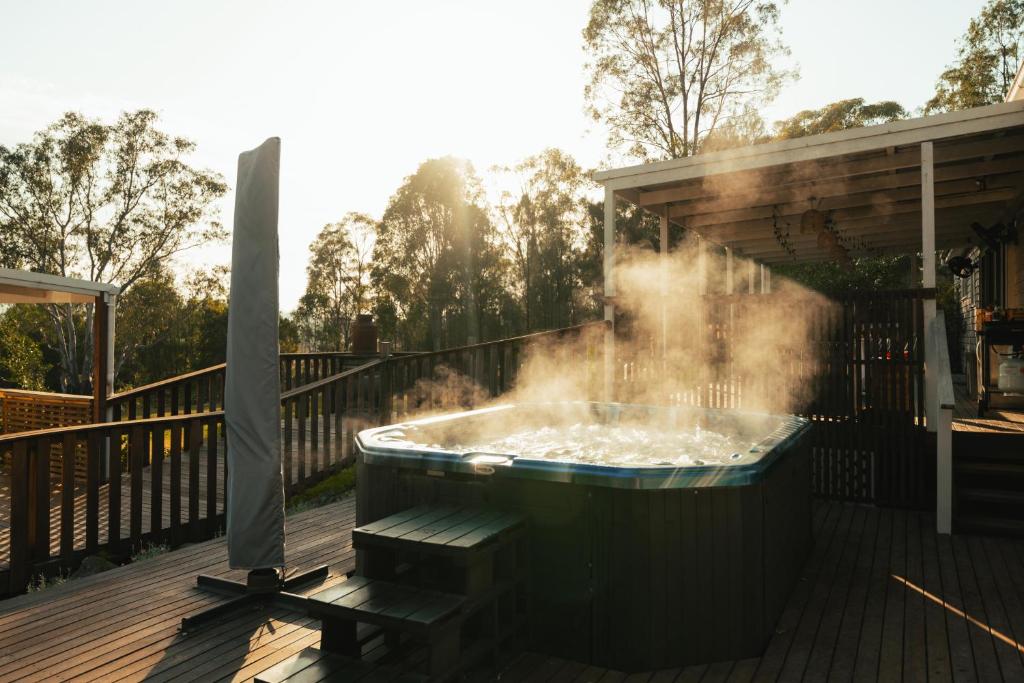 a hot tub on a deck with steam coming out at Hunter Moon Country House, Hunter Valley in Broke