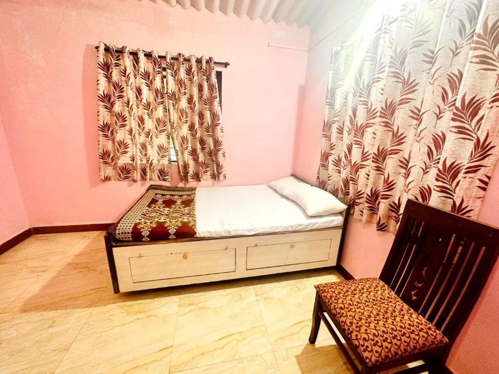 una piccola camera con letto e sedia di Homestay 2 bhk near beach ad Alibaug