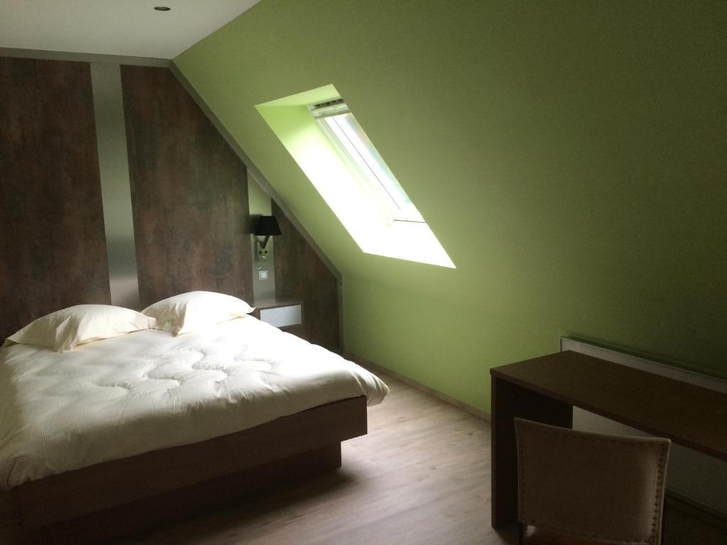 ein Schlafzimmer mit einem Bett und einem Dachfenster in der Unterkunft Chambres d'Hotes Chez Marie in Seltz