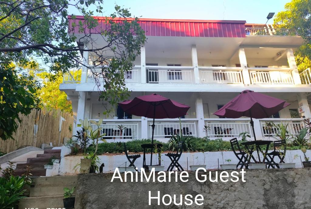 anandan guest house with tables and umbrellas in front of it at Ani Marie Guest House in Coron