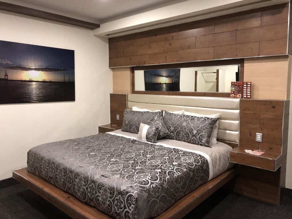 a bedroom with a large bed with a wooden headboard at HOTEL BUGAMBILIAS in Ensenada