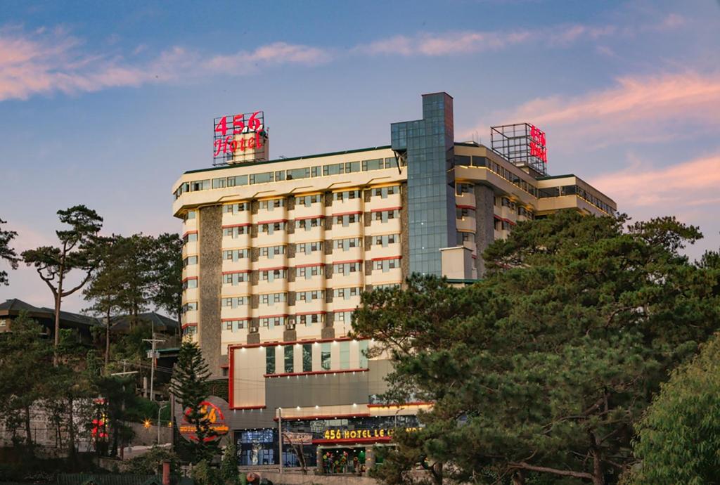 un edificio alto con árboles delante de él en 456 Hotel en Baguio