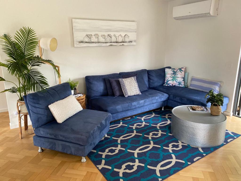 sala de estar con sofá azul y alfombra en McCrae Beach Front Villa Unit 1, en McCrae