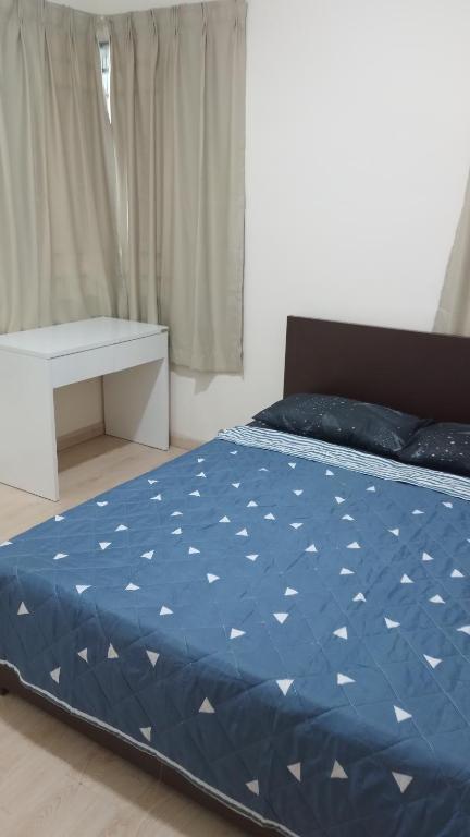 Schlafzimmer mit einem Bett mit blauer Decke in der Unterkunft Santai Homestay in Kota Kinabalu