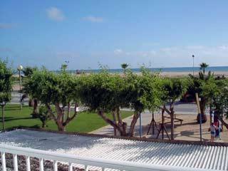 un parque con árboles y una valla blanca en Apartamento Verano, en Conil de la Frontera