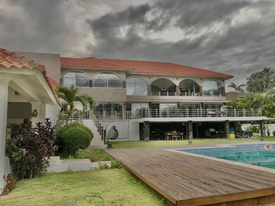a large house with a pool and a wooden deck at Lujosa Villa en Casa de Campo Golf La Romana R.D in La Romana