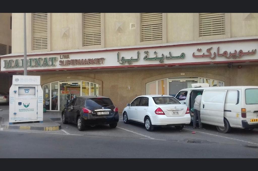 un gruppo di auto parcheggiate di fronte a un edificio di 1 bed apartment available in Al nadd a Sharjah