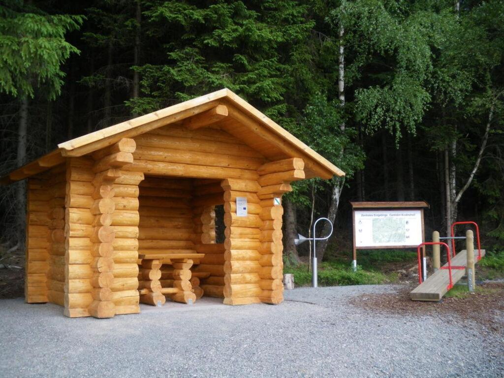 a small log cabin with a playground in a park at Däumler "House Am Weißwald" in Breitenbrunn