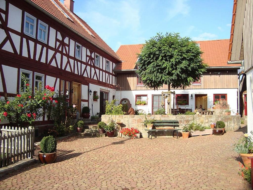 a courtyard of a building with a bench and a tree at Stork's Nest Modern retreat in Eichenzell