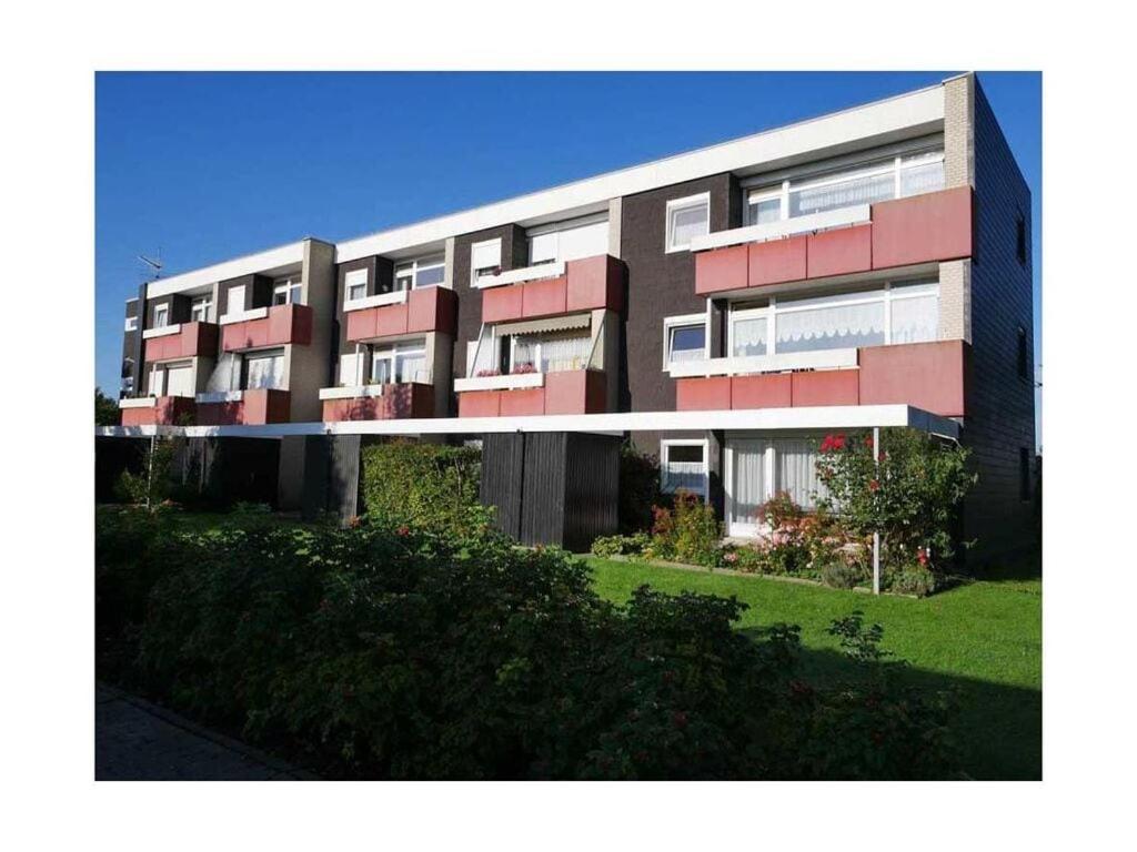 ein großes Apartmenthaus mit roten und weißen Fenstern in der Unterkunft "Schnepfenweg" 39 Merchant in Horumersiel