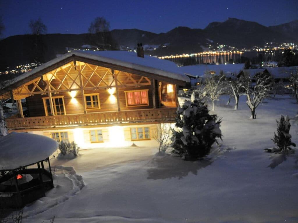 a log cabin in the snow at night at Suite Nuss Modern retreat in Bad Wiessee