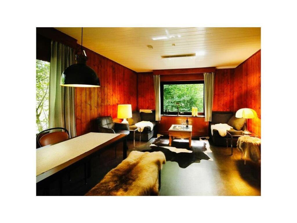 sala de estar con paredes de madera y sofá grande en Forest house in the Roman valley, en Morsbach